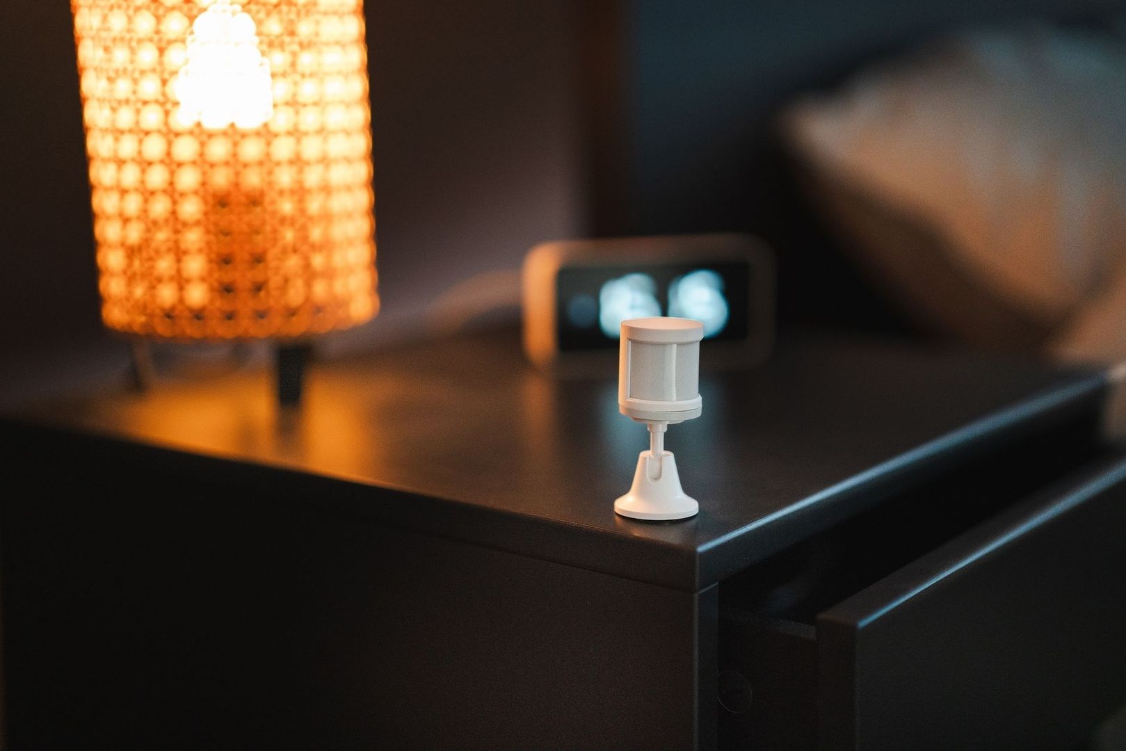 Lille hvid sensor står på et bord i et varmt oplyst hjem